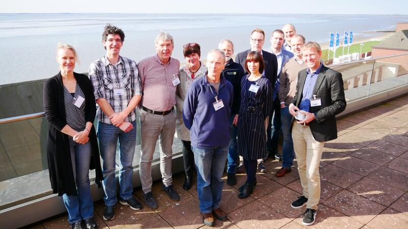 Group picture of symposium speakers and moderators with Wadden Sea in background. © CWSS.